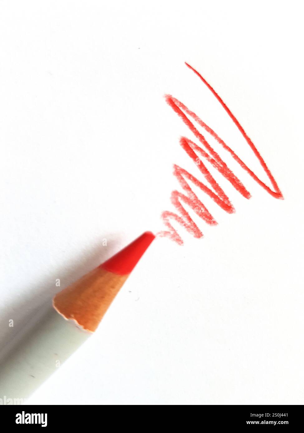 Primo piano di una matita rossa e scarabocchiate su uno sfondo bianco. Foto Stock