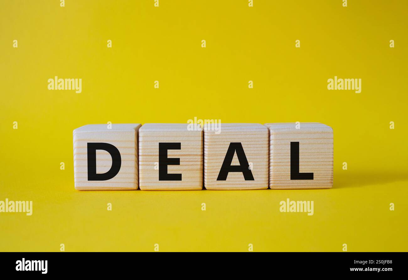 Simbolo dell'accordo. Concept Word deal su cubi di legno. Bellissimo sfondo giallo. Concetto di affari e affari. Copia spazio. Foto Stock