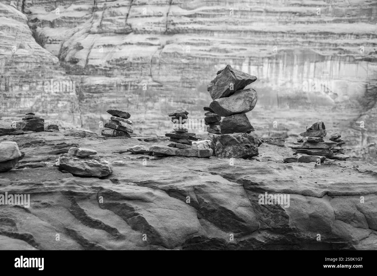 Un mucchio di rocce è impilato l'uno sull'altro in un'area rocciosa. L'immagine ha una sensazione di calma e desolazione, con le rocce in piedi da sole nel vasto, r Foto Stock Un mucchio di rocce è impilato l'uno sull'altro in un'area rocciosa. L'immagine ha una sensazione di calma e desolazione, con le rocce in piedi da sole nel vasto, r Foto Stock