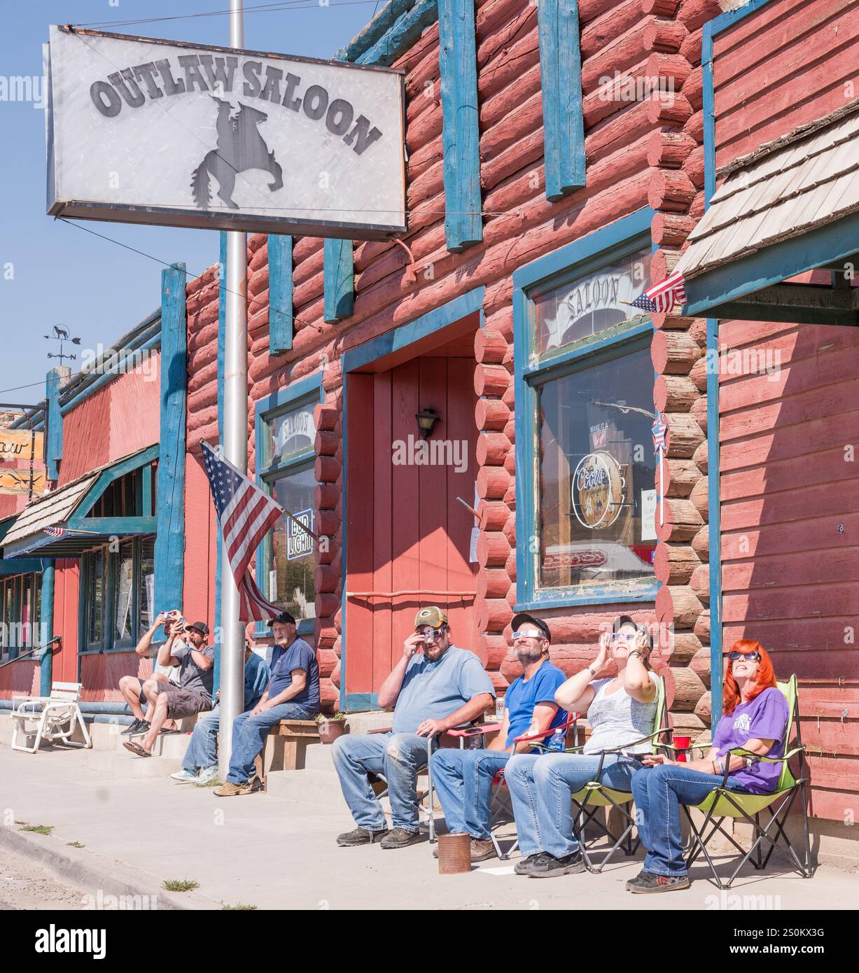 Dubois WY USA - 21 agosto 2017: Gruppo di persone che guardano l'eclissi solare di fronte all'Outlaw Saloon. Foto Stock