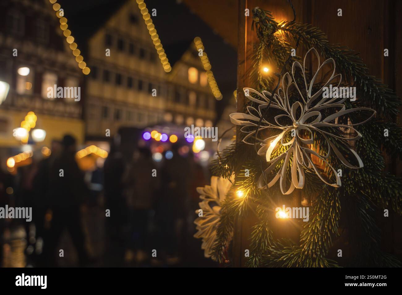 Primo piano di una decorazione natalizia di notte con le case tradizionali illuminate dietro, il mercato natalizio di vitello, la Foresta Nera, la Germania, l'Europa Foto Stock