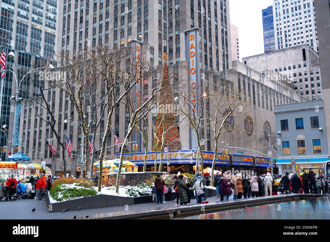 Midtown Manhattan è affollata di turisti, acquirenti e newyorkesi locali l'ultimo sabato e il primo giorno d'inverno prima di Natale. Albero di Natale del radio City Music Hall. Foto Stock