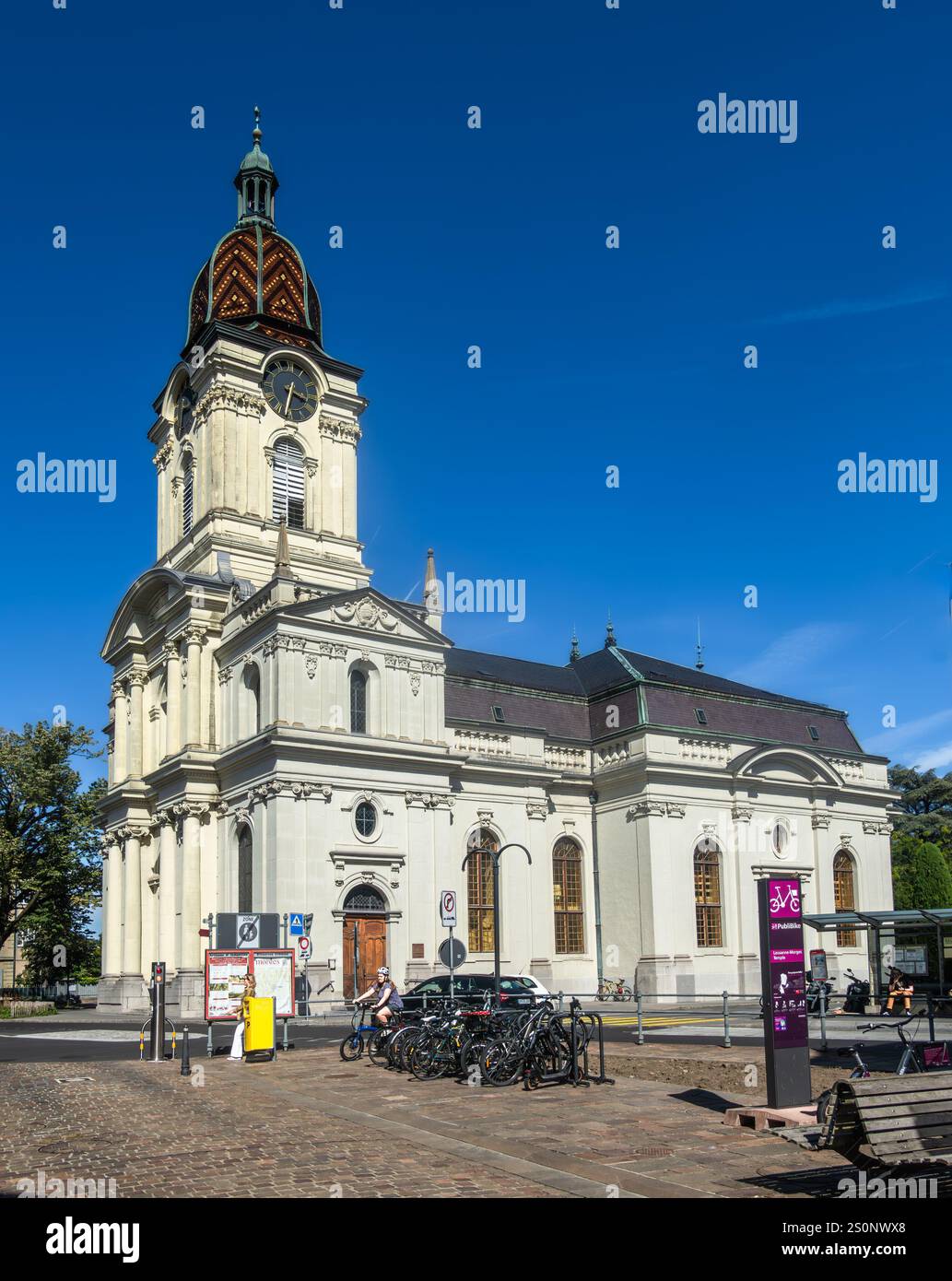 Morges, Svizzera - 6 settembre 2024: Una chiesa protestante riformata con un'alta torre dell'orologio e architettura classica, si erge sotto un trasparente BL Foto Stock