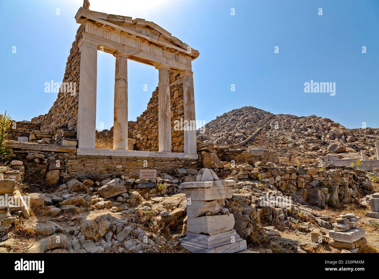 Le rovine dell'antico Tempio di pietra su una collina rocciosa sotto il cielo azzurro, Delo, Grecia Foto Stock