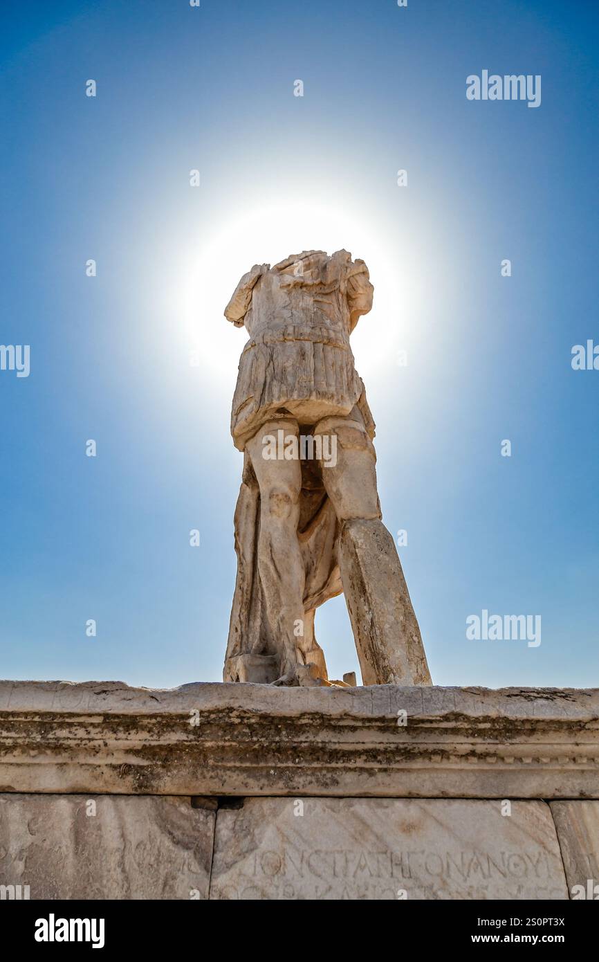 Antica statua di pietra in piedi contro un cielo luminoso illuminato dal sole, Delo, Grecia Foto Stock
