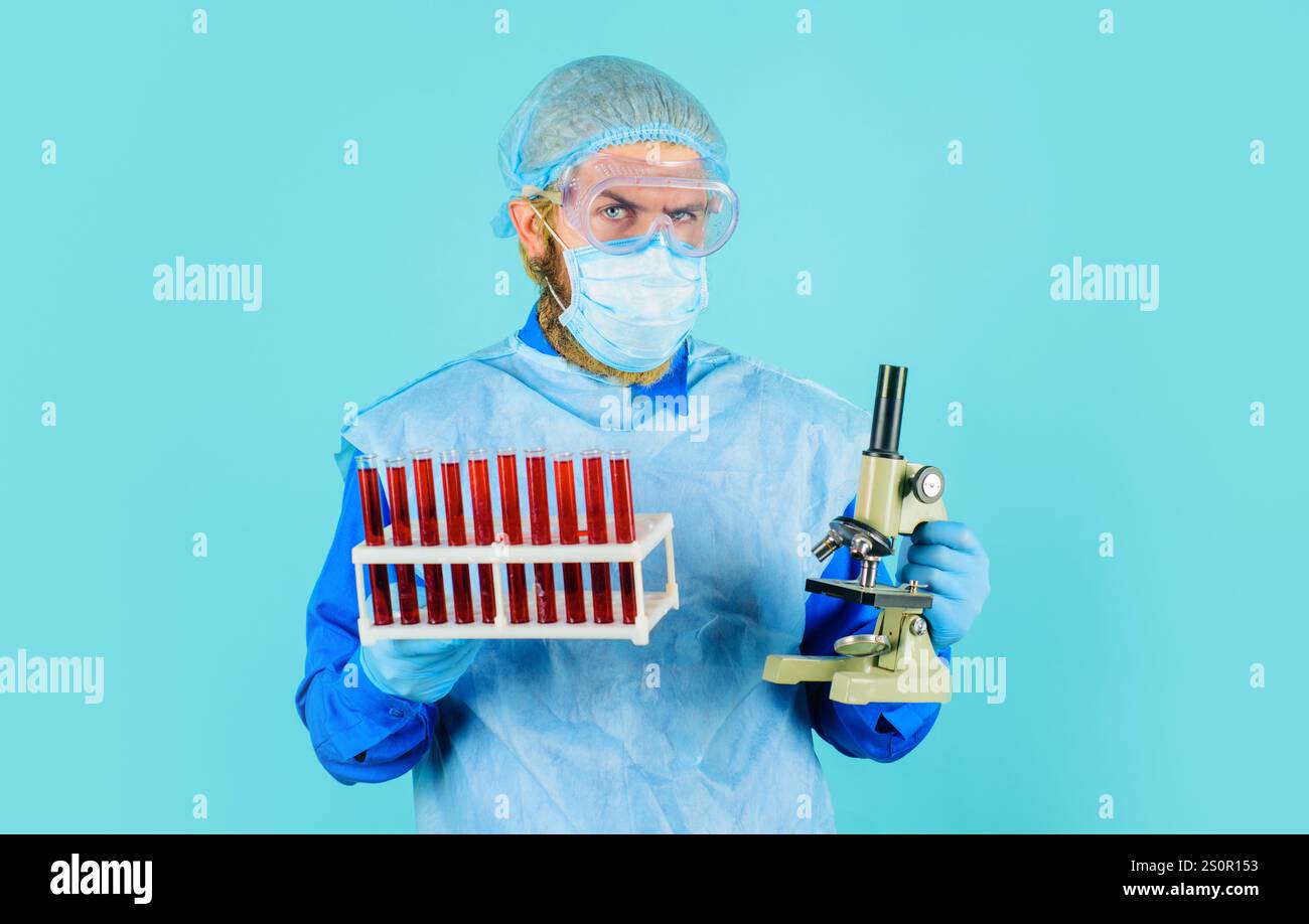 Analisi del sangue. Medico che lavora con i campioni di sangue del paziente. Test sierologici in ospedale. Scienziato medico o assistente di laboratorio in maschera e occhiali Foto Stock