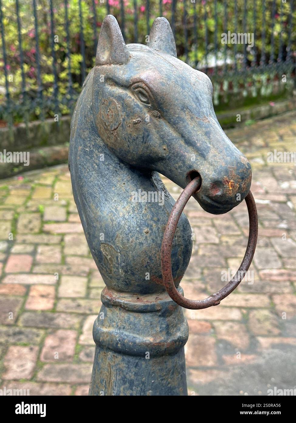 Nel Garden District di New Orleans, Louisiana, durante il giorno, viene mostrato un vecchio palo in metallo per l'aggancio dei cavalli in una vista verticale. Foto Stock