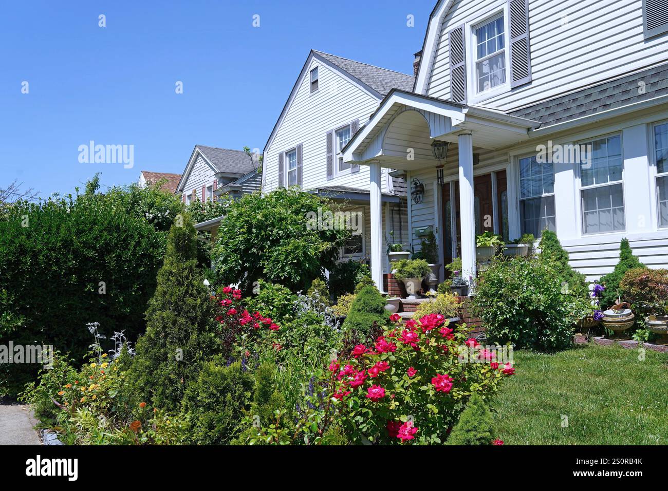 Strada con fila di tradizionali case indipendenti con frontoni e pareti bianche Foto Stock