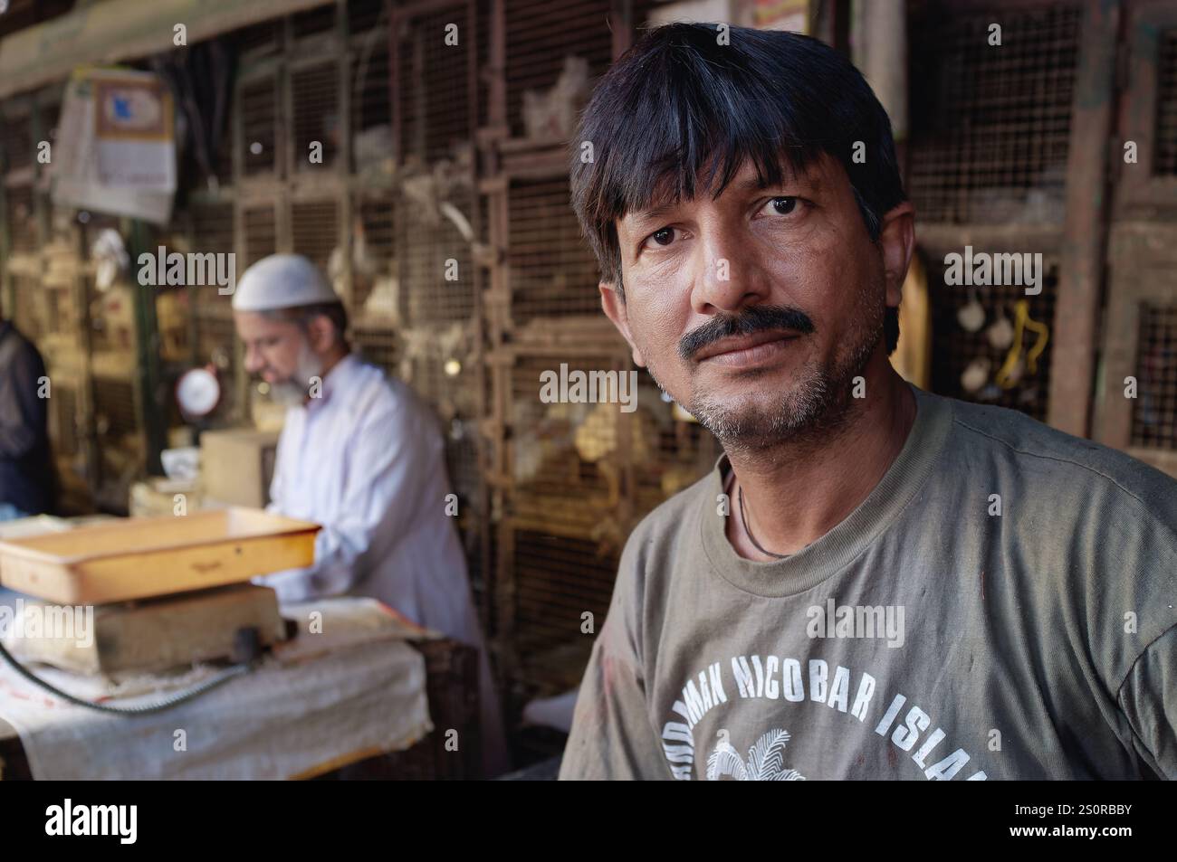 Ritratto di un uomo musulmano indiano di mezza età impiegato in un macellaio (pollo) a conduzione musulmana in un mercato a Byculla, Mumbai, India Foto Stock