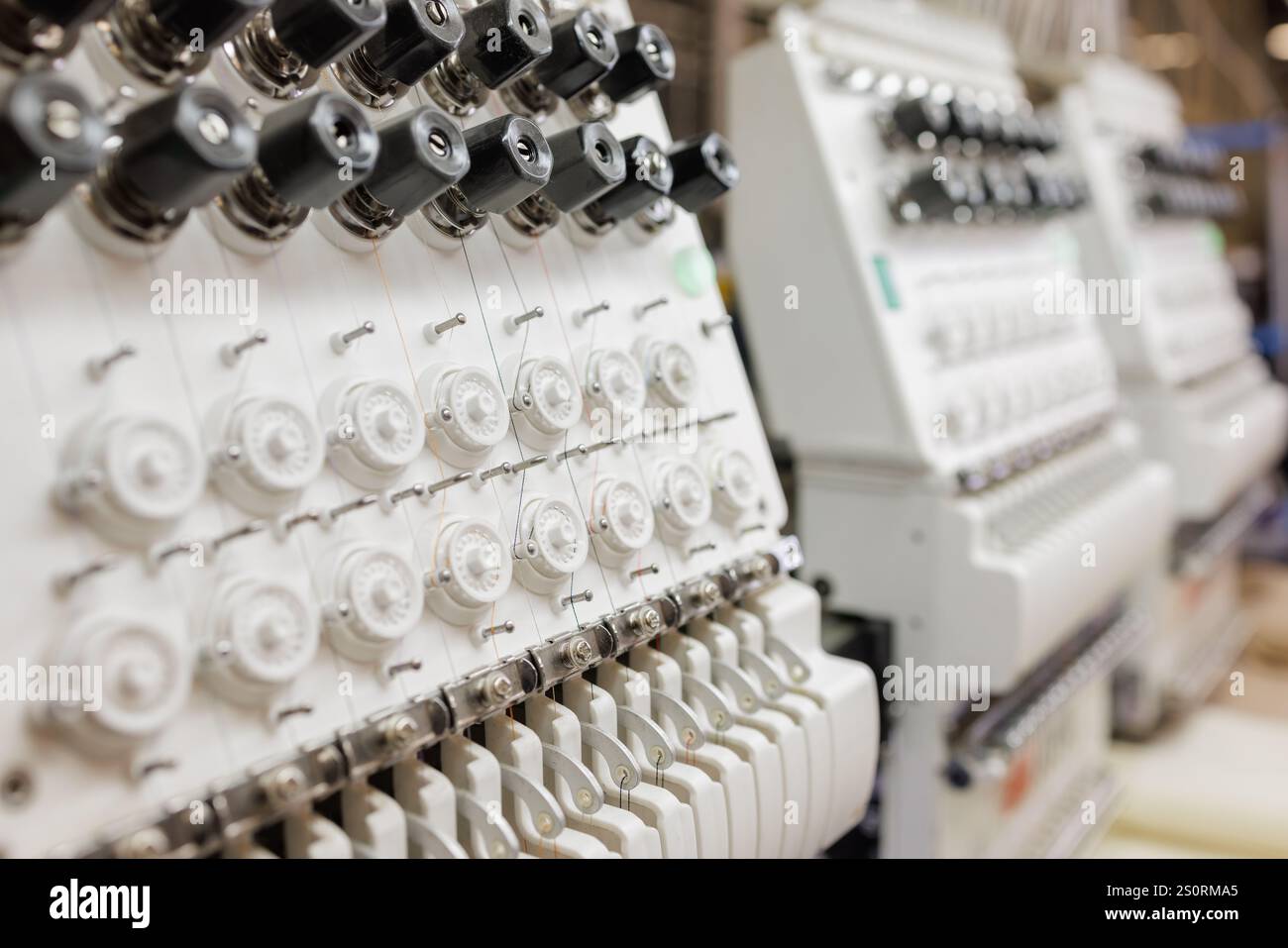 Telaio per tessitura industriale in una fabbrica di tessitura, macchina da ricamo, applicazione del ricamo al tessuto. Foto Stock
