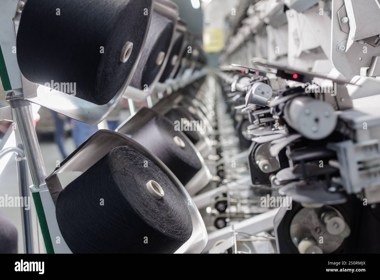 Fabbrica tessile, linea di produzione di filatura, primo piano di attrezzature per la produzione di tessuti, tessitrice, Foto Stock
