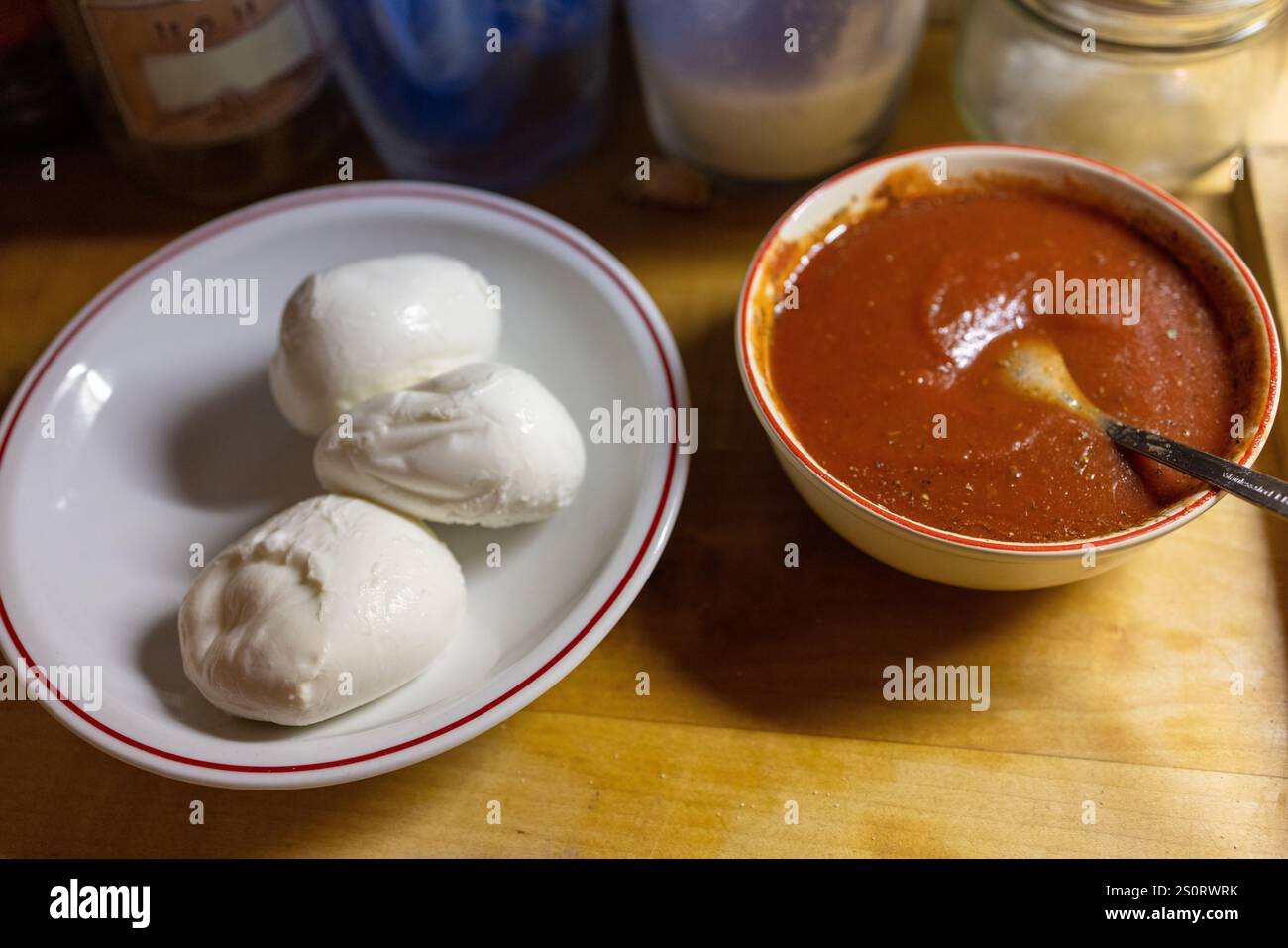 Mozzarella fresca e salsa di pomodoro su un bancone di legno Foto Stock
