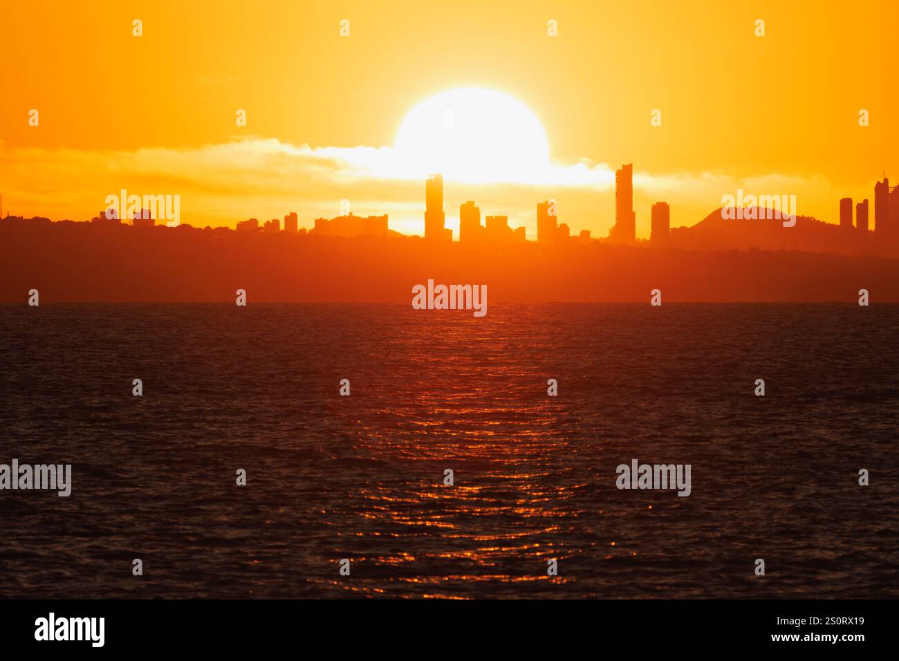 Sole sui grattacieli nella silhouette di Benidorm al tramonto da Calpe, Spagna Foto Stock