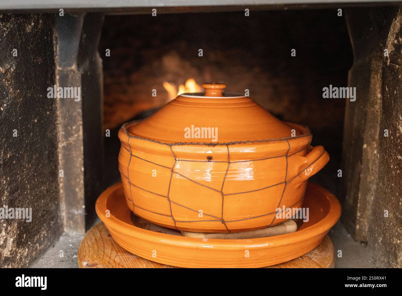 Tradizionale pentola di argilla cucinata in un forno a legna Foto Stock