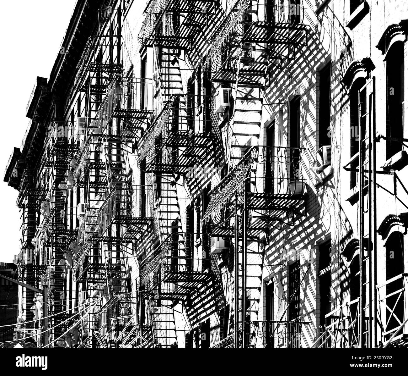 Una fotografia in bianco e nero che mostra una fila di edifici con intricate fuochi d'incendio. Le ombre gettate dalle fuochi creano un motivo suggestivo Foto Stock