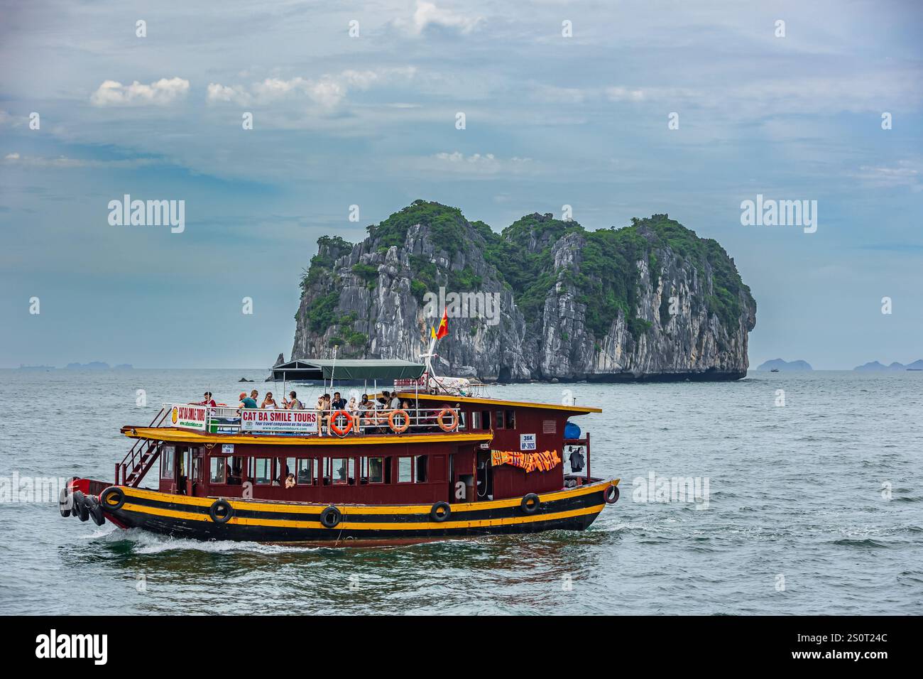 Crociera in barca a vela tra le rocce dell'isola di Cat Ba. Un tour in barca con i turisti a bordo che portano persone lungo la baia di ha Long in Vietnam. Cat Ba Tour Crui Foto Stock