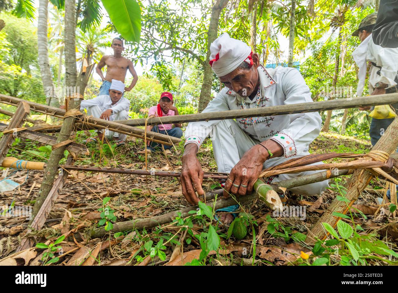 Un anziano Arumanen Manuvu tribale in abiti tradizionali che mostra una trappola per animali tribali utilizzata nella caccia a Cotabato nelle Filippine Foto Stock