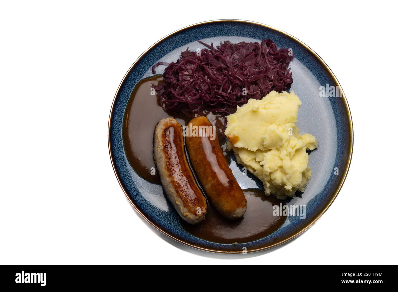 Traditionelles Gericht mit Bratwurst und Beilagen , Deutschland, 29.12.2024, Bratwürste mit dunkler Soße, Rotkohl und cremigem Kartoffelpüree auf einem blauen Teller ein klassisches deutsches Gericht. *** Piatto tradizionale con bratwurst e contorni , Germania, 29 12 2024, bratwurst con salsa scura, cavolo rosso e crema di patate su un piatto blu un classico piatto tedesco Foto Stock