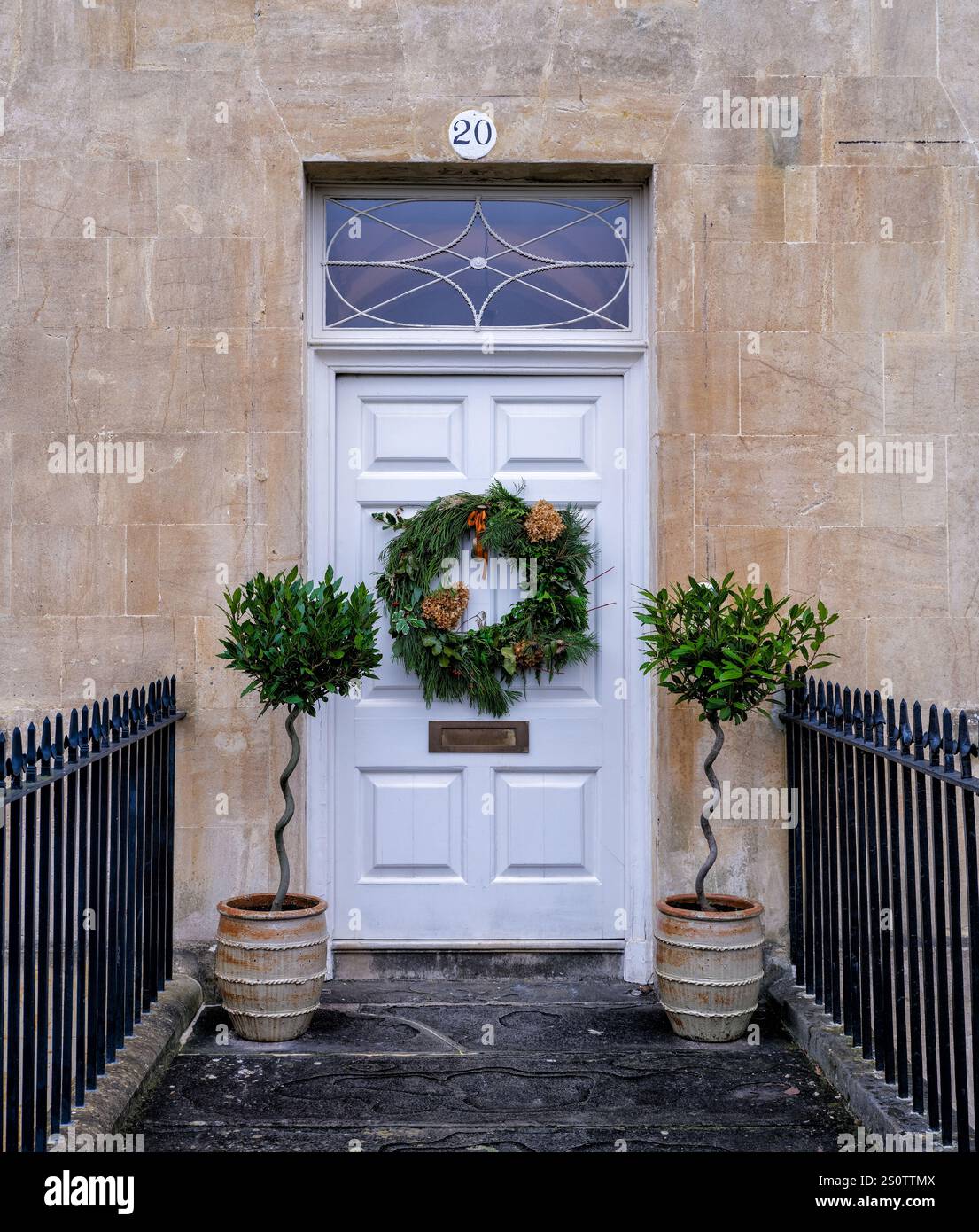 Corona di Natale sull'elegante porta d'ingresso di una casa sulla Royal Crescent a Bath, Somerset, Regno Unito Foto Stock