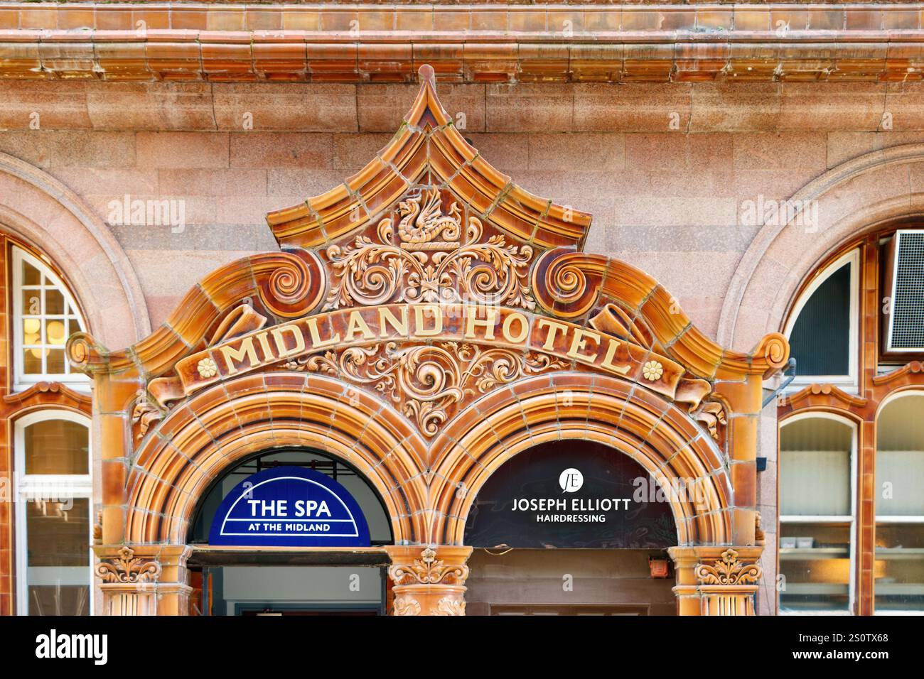 Decorazioni architettoniche della facciata sopra l'ingresso dello storico Midland Hotel, che mostrano intricati lavori in pietra ed eleganti piastrelle smaltate Foto Stock