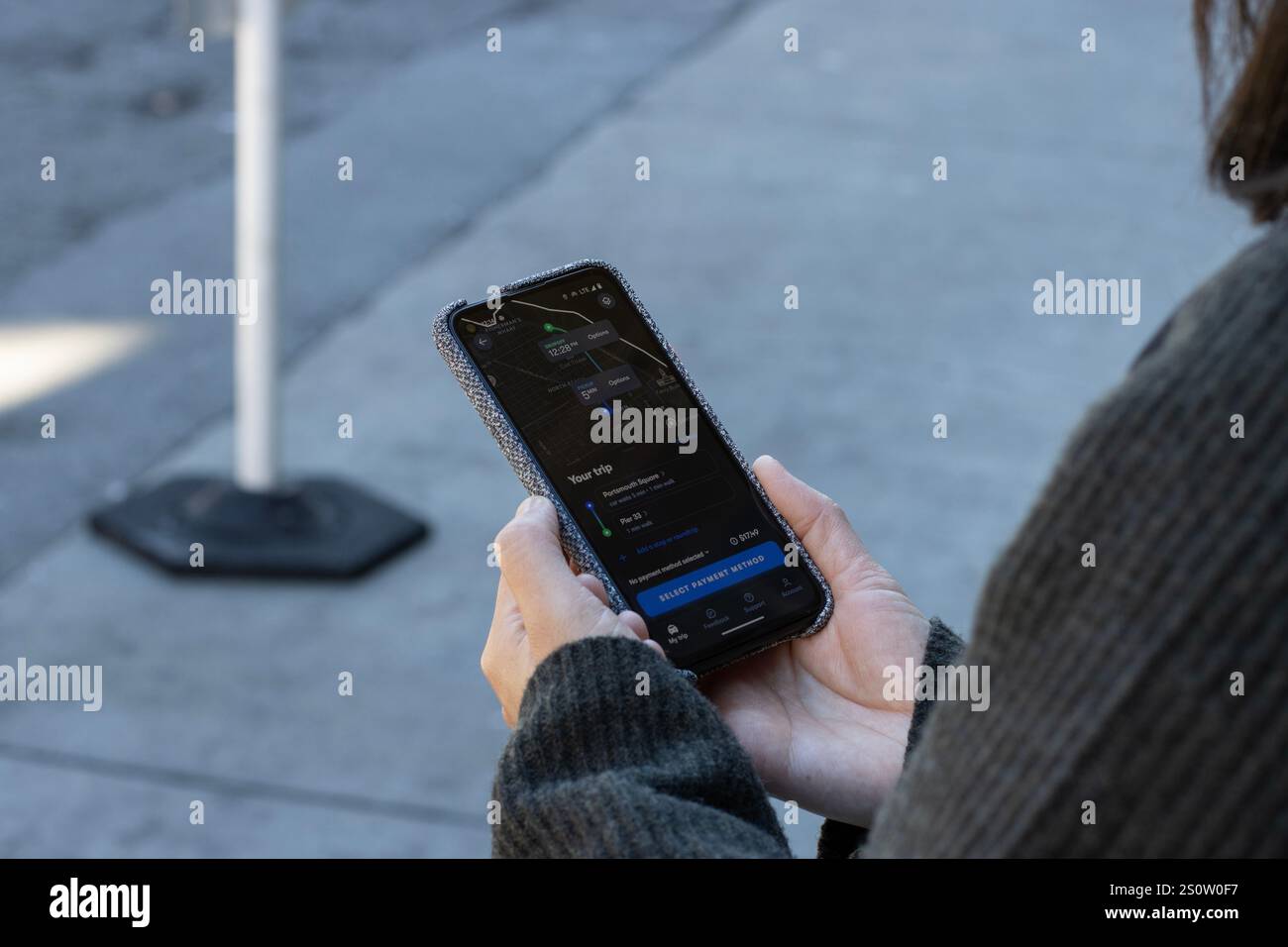 Una donna usa l'app Waymo One per fare un giro in robotaxi da Portsmouth Square a Chinatown al Molo 33 a San Francisco giovedì 27 novembre 2024. Foto Stock