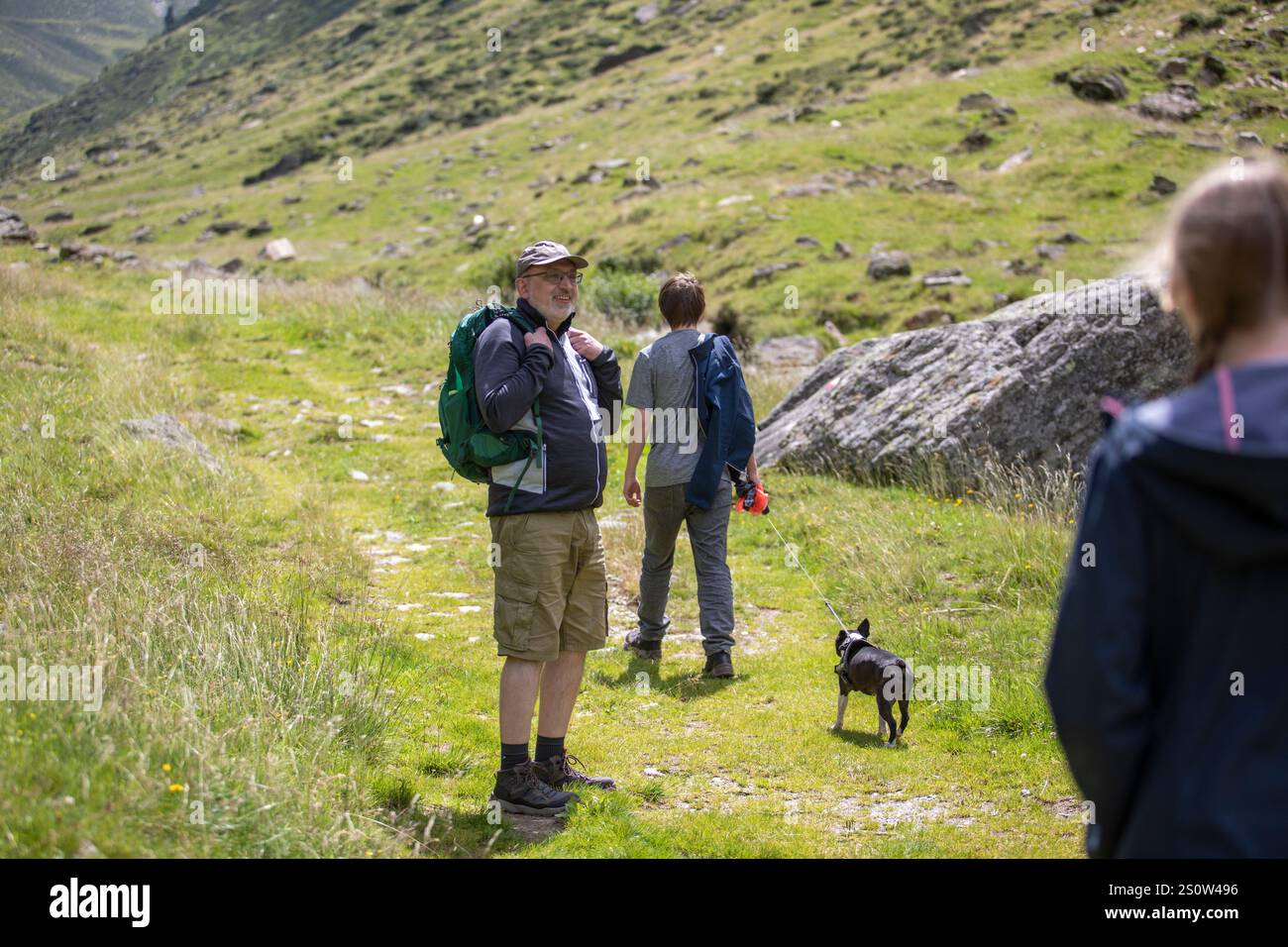 Un'escursione in famiglia in montagna durante l'estate, godendosi la natura con il proprio cane. Questa emozionante scena cattura la gioia di stare insieme, esplorare, Foto Stock