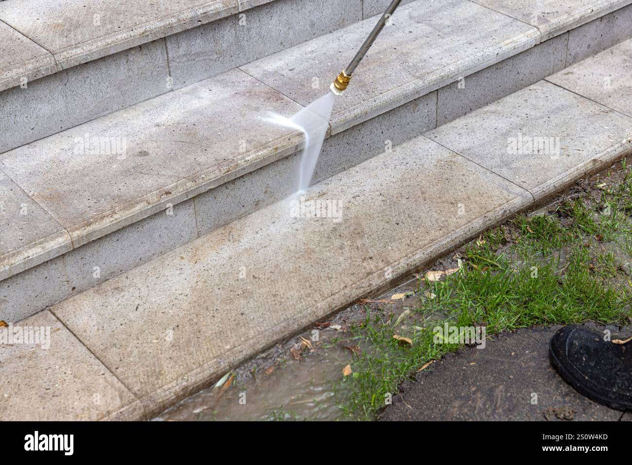 Il servizio di pulizia all'aperto prevede il lavaggio di scale in pietra con getto d'acqua ad alta pressione Foto Stock