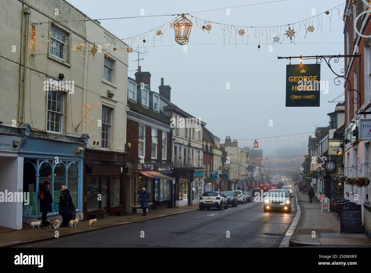 Battle High Street, East Sussex, Regno Unito, la vigilia di Natale 2024, con luci natalizie e nebbia Foto Stock
