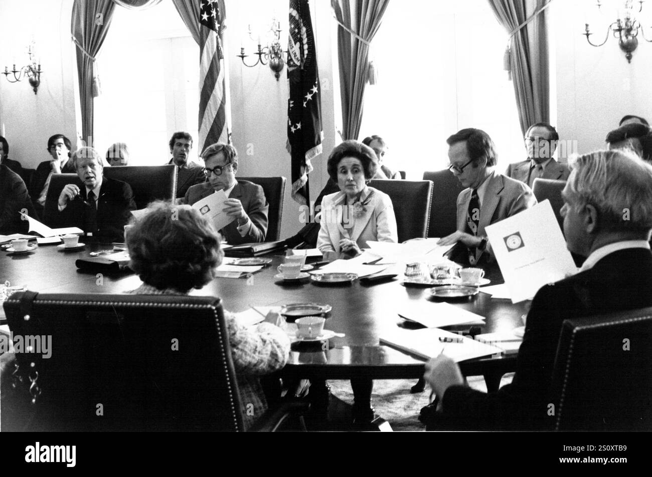 Il presidente degli Stati Uniti Jimmy Carter, a sinistra, e il segretario all'energia James R. Schlesinger, all'estrema destra con Back to the camera, discutono il rapporto della CIA sulla situazione energetica internazionale in una riunione del gabinetto della Casa Bianca a Washington, DC il 18 aprile 1977. Il Presidente dovrebbe consegnare un discorso energetico alla nazione in diretta televisiva la sera. Nelle sue osservazioni, il Presidente equiparerà la crisi energetica all'equivalente morale della guerra. Da sinistra a destra: Presidente Carter, Segretario alla difesa degli Stati Uniti Harold Brown, Segretario al commercio degli Stati Uniti Juanita M. Kre Foto Stock