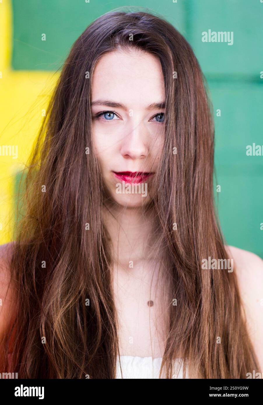 Bella bruna contro un muro colorato Foto Stock