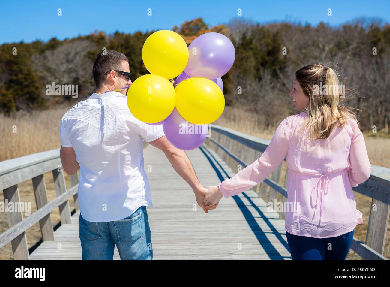 Presto i genitori camminano sul ponte tenendosi per mano guardando ciascuno Foto Stock
