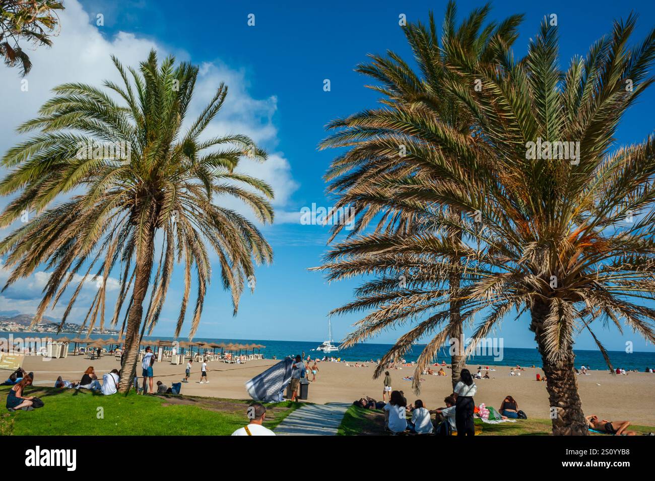 Malaga, Spagna, grande folla di persone, turisti, prendere il sole sulla spiaggia, godersi il tempo primaverile Foto Stock