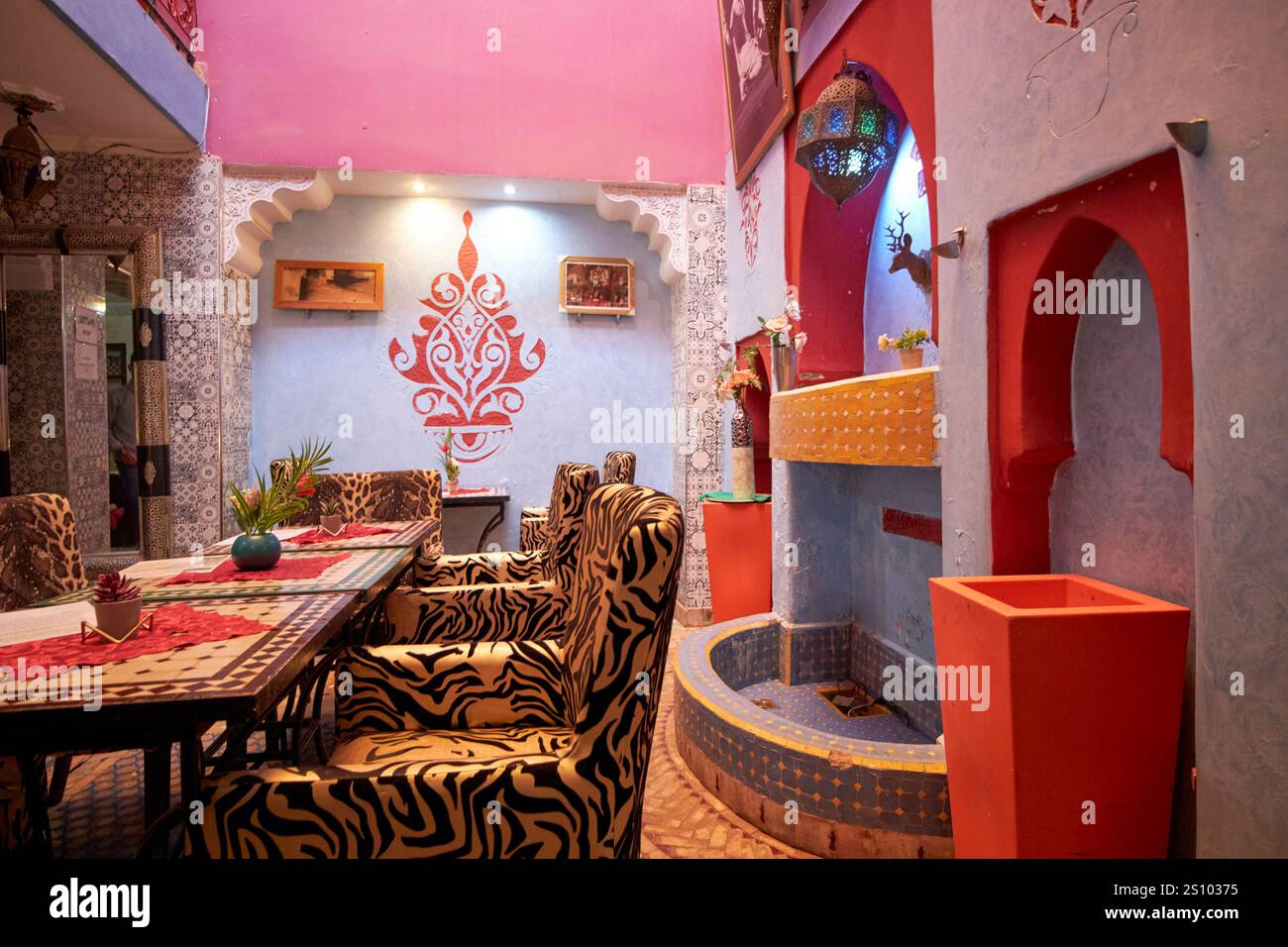 cortile interno di un piccolo riad con tavoli e posti a sedere a marrakech, marocco Foto Stock