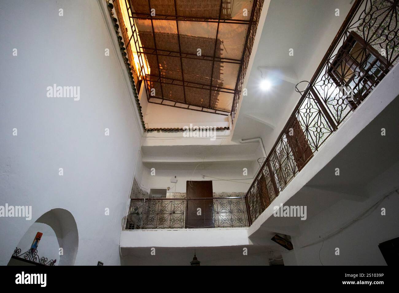 cortile interno di un piccolo riad con balconi e coperture sul tetto dell'atrio aperto a marrakech, marocco Foto Stock