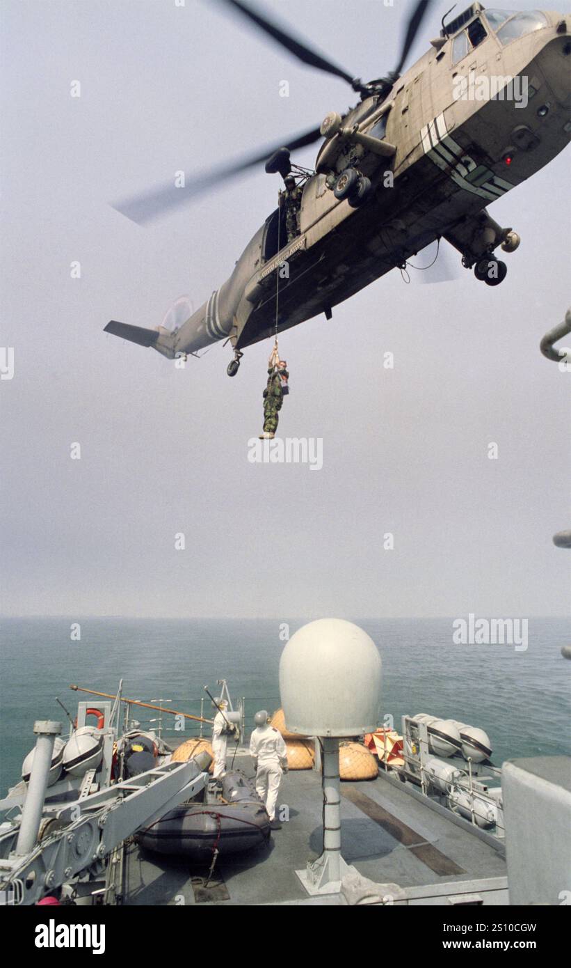 Prima guerra del Golfo: 20 marzo 1991 il winchman su un 845 Naval Air Squadron Westland Sea King HC. Mk 4/HA. L'elicottero mk 5, numero di serie ZA312 B, abbassa un membro dell'equipaggio sulla HMS Dulverton (M35) durante le operazioni di sminamento al largo del porto di Shuaiba in Kuwait. Foto Stock