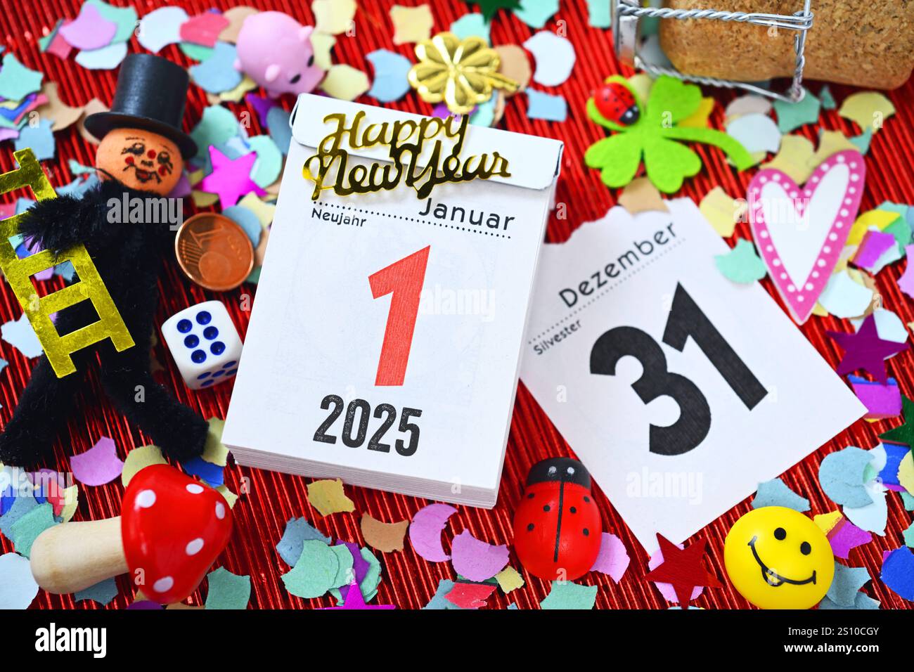 FOTOMONTAGE, Kalenderblätter vom 31. Dezember und 1. Januar umgeben von Glückssymbolen und Konfetti, Symbolfoto Neujahr 2025 *** FOTOMONTAGGIO, pagine del calendario dal 31 dicembre al 1 gennaio circondate da simboli e coriandoli fortunati, foto simbolica Capodanno 2025 Foto Stock