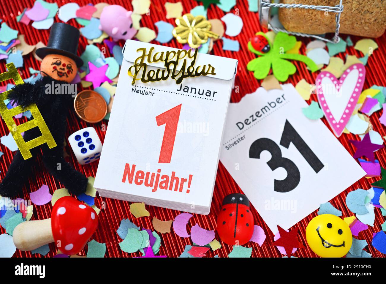 FOTOMONTAGE, Kalenderblätter vom 31. Dezember und 1. Januar mit Aufschrift Neujahr umgeben von Glückssymbolen und Konfetti, Symbolfoto Neujahr 2025 *** FOTOMONTAGGIO, pagine di calendario dal 31 dicembre al 1 gennaio con l'iscrizione Capodanno circondato da simboli fortunati e coriandoli, foto simbolica Capodanno 2025 Foto Stock