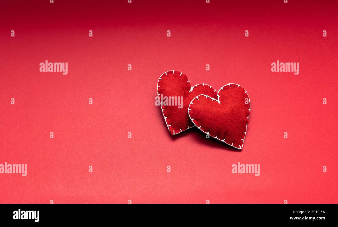 astrazione di amore e relazione, cuori rossi di lana fatti a mano su sfondo rosso, incontri e concetto di san valentino Foto Stock