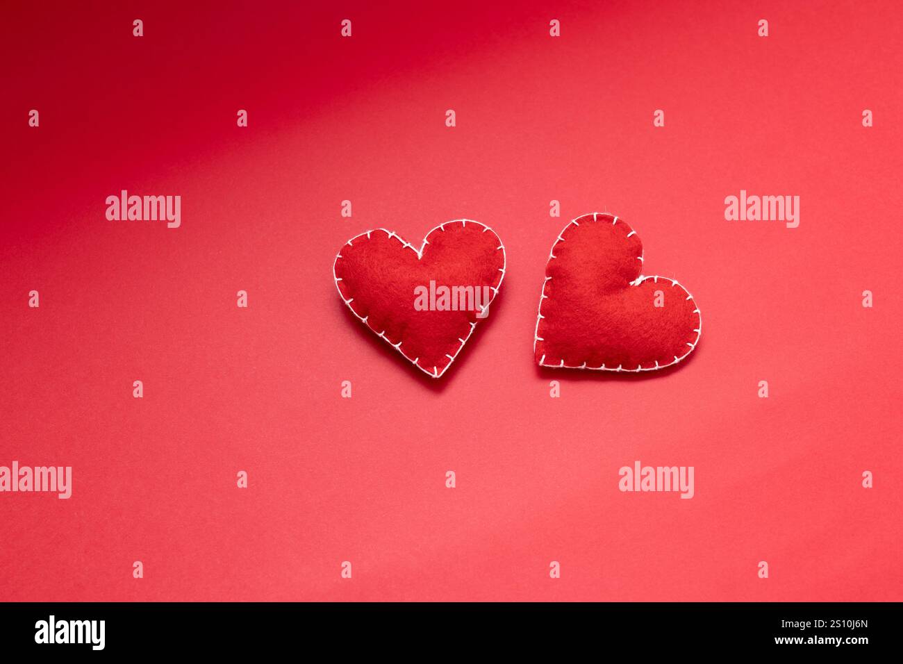 astrazione di amore e relazione, cuori rossi di lana fatti a mano su sfondo rosso, incontri e concetto di san valentino Foto Stock