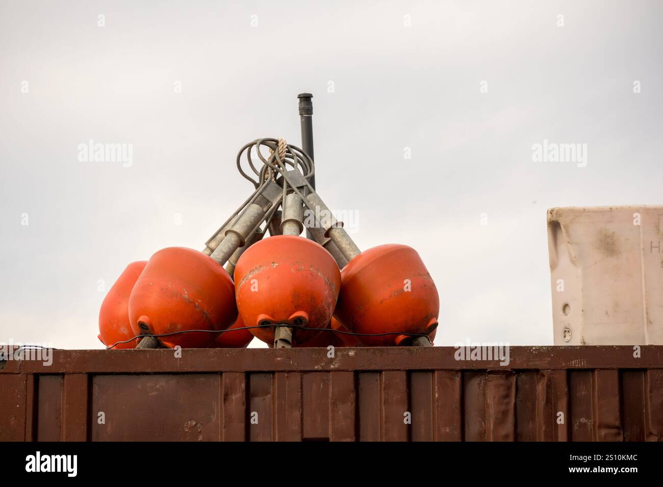 Diverse boe arancioni impilate sulla parte superiore di una struttura in cemento. Le boe sono dotate di dispositivi di fissaggio in metallo che consentono di fissarle a varie strutture. Foto Stock