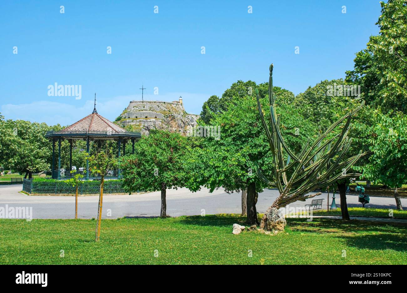 Il Padiglione della musica Spianada nel Parco Platia Leonida Vlachou nel centro storico della città Vecchia di Corfù, in Grecia. La Fortezza Vecchia del XV secolo sullo sfondo Foto Stock
