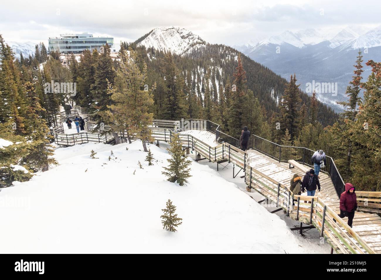 I turisti salgono le scale di legno fino alla Sulphur Mountain Cosmic Ray Station per godersi la vista invernale del Parco Nazionale di Banff in Alberta, Canada Foto Stock