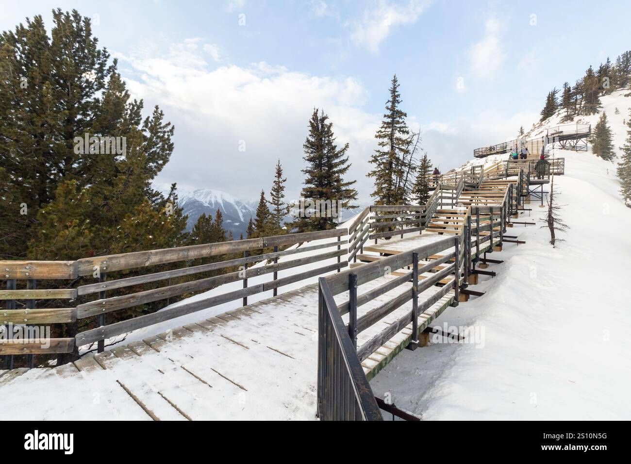 I turisti salgono le scale di legno fino alla Sulphur Mountain Cosmic Ray Station per godersi la vista invernale del Parco Nazionale di Banff in Alberta, Canada Foto Stock