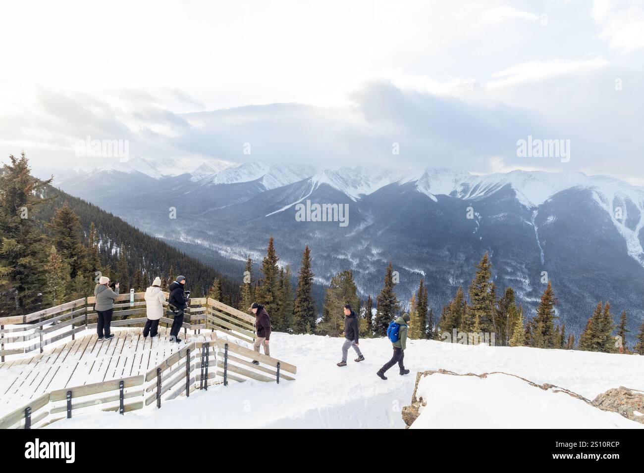 I turisti salgono le scale di legno fino alla Sulphur Mountain Cosmic Ray Station per godersi la vista invernale del Parco Nazionale di Banff in Alberta, Canada Foto Stock