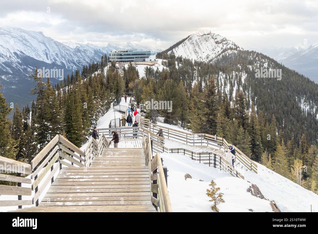 I turisti salgono le scale di legno fino alla Sulphur Mountain Cosmic Ray Station per godersi la vista invernale del Parco Nazionale di Banff in Alberta, Canada Foto Stock