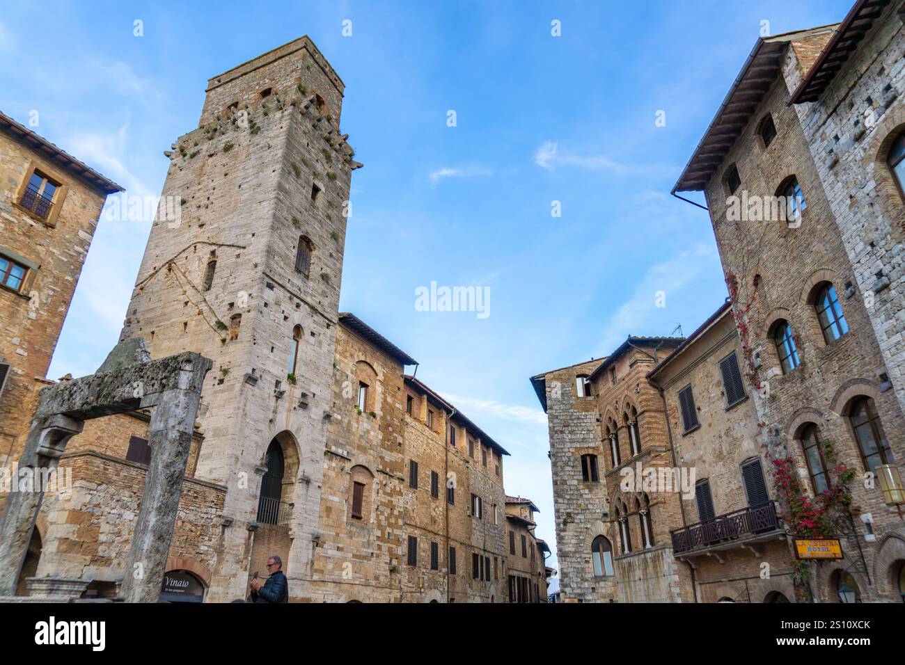 Piazza della Cisterna e la Torre del Diavolo o Torre del Diavolo nella città medievale di San Gimignano, Italia. A destra si trova Palazzo Tortoli Foto Stock