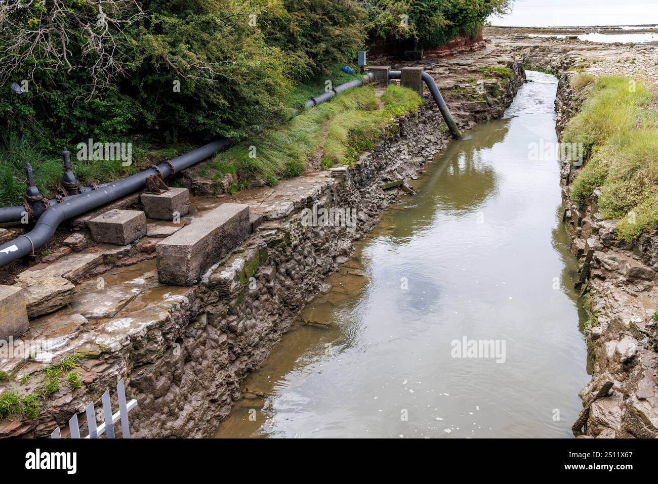 Canale di drenaggio verso il mare, Barry, Wales, Regno Unito Foto Stock