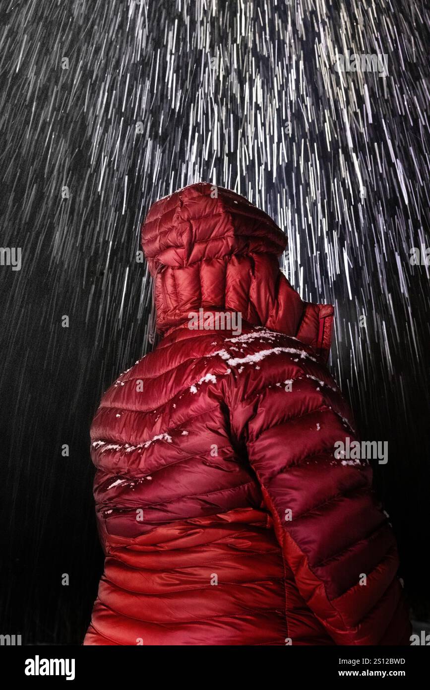 Donna su strada rurale con neve pesante che cade nella contea di Mecosta, Michigan, Stati Uniti Foto Stock