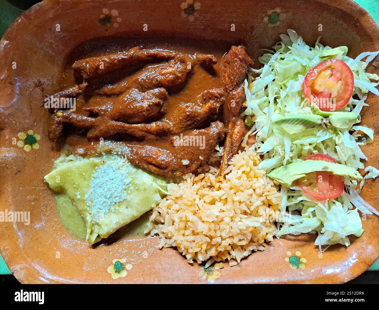 Piatto preparato con cosce di rana in salsa rossa con riso e insalata considerati una specialità culinaria Foto Stock