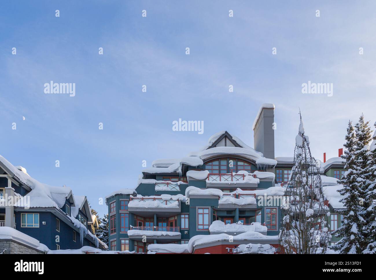 Turismo invernale in montagna - una passeggiata in villaggio alpino con case, Lodge, caffè e stazioni sciistiche. neve bianca pura e luce solare. Whistler, Foto Stock